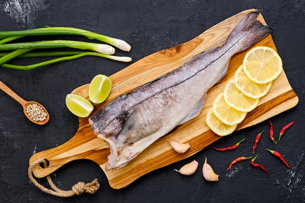 Top view of raw fresh haddock carcass on wooden cutting board