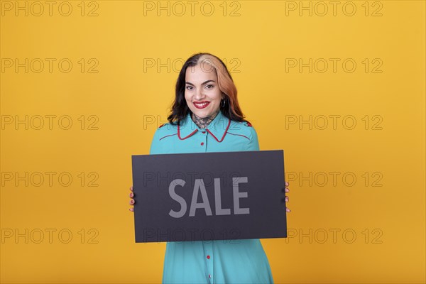 Beautiful woman holding a Sale sign. Commercial concept. Commerce