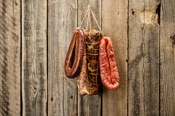 Assortment of dried meat and sausages hanging on a barn wall