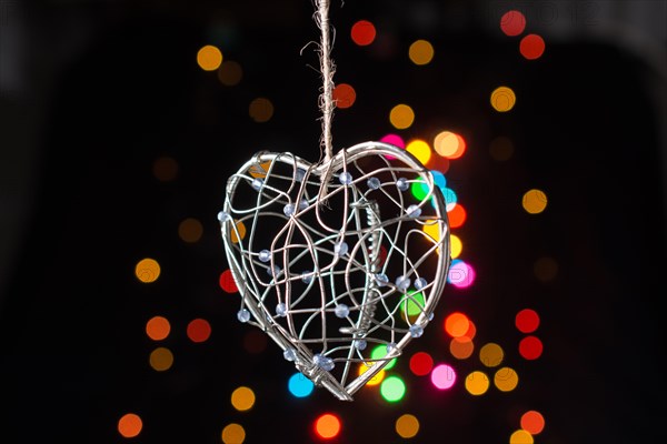 Heart shaped metal cage on a bokeh light background