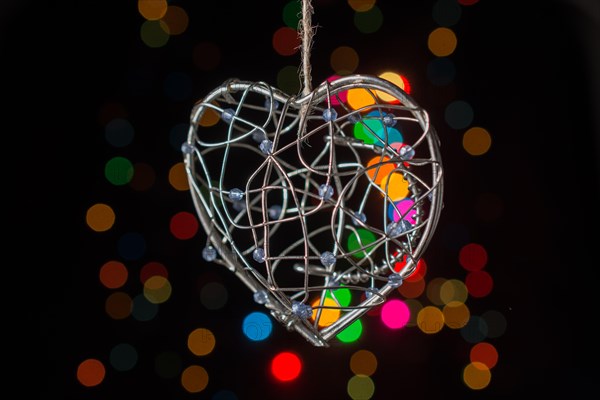 Heart shaped metal cage on a bokeh light background