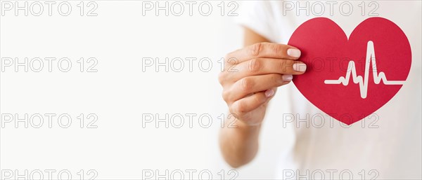 Front view woman holding paper heart with heartbeat