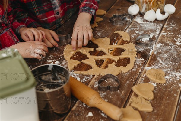 High angle children making cookies together home