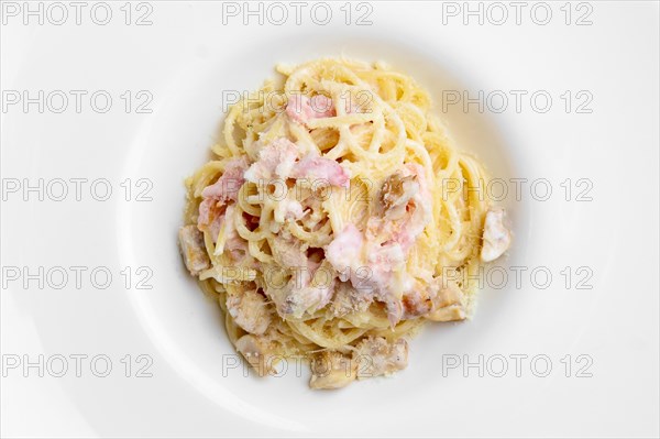 Top view of plate with spaghetti with mushrooms and bacon