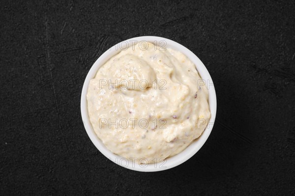 Overhead view of small bowl with caesar sauce for salad