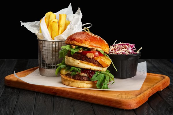 Big burger with french fries and cabbage salad