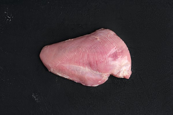 Raw fresh turkey boneless breast without skin on dark background