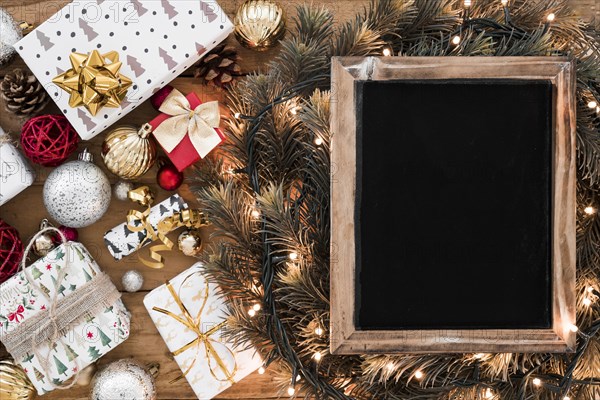 Photo frame fir twigs fairy lights near christmas decorations