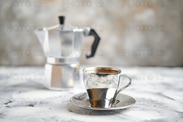 Geyser coffee maker and metal cup on abctract background