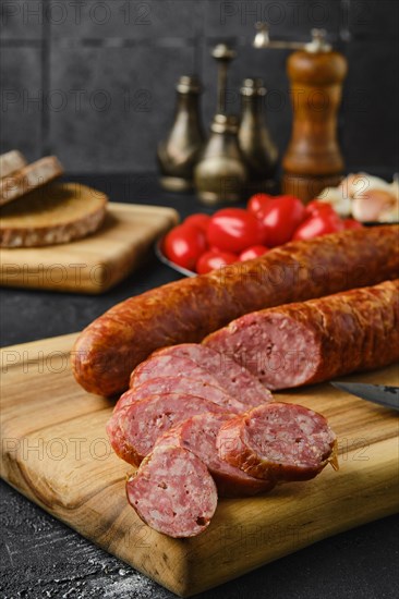 Closeup view of smoked beef sausage rings on wooden cutting board on kitchen table