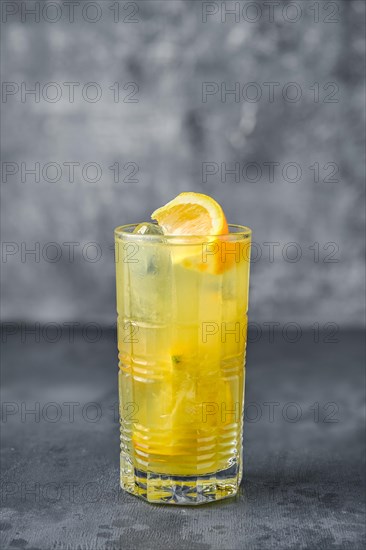 Alcohol cocktail with rum and orange juice on gray background
