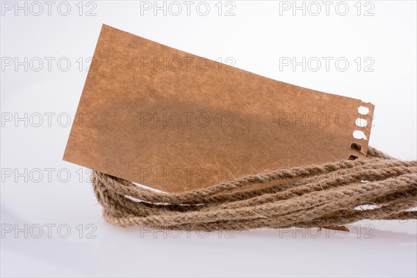 Piece of paper and linen rope on a white background
