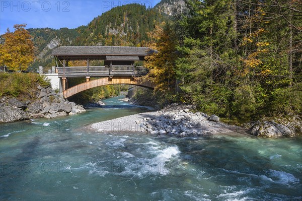 Wooden bridge over the Ostrach in the autumnal Ostrachtal