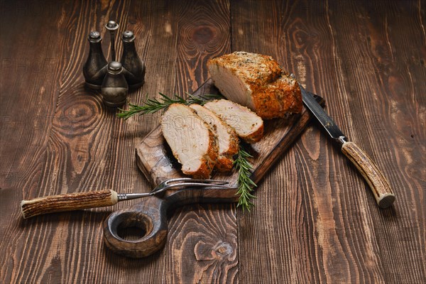 Pork collar joint baked in oven on wooden cutting board