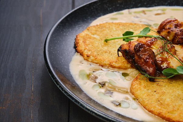 Closeup view of potato fritters with teriyaki chicken fillet