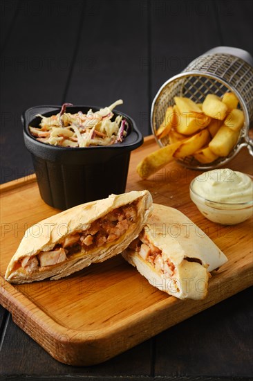 Tostada with chicken fillet served with cabbage salad and american fries on wooden tray