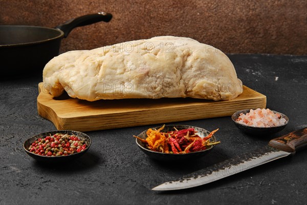 Lamb fat tail on kitchen table with salt and pepper