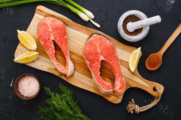 Raw fresh salmon steak on wooden cutting board