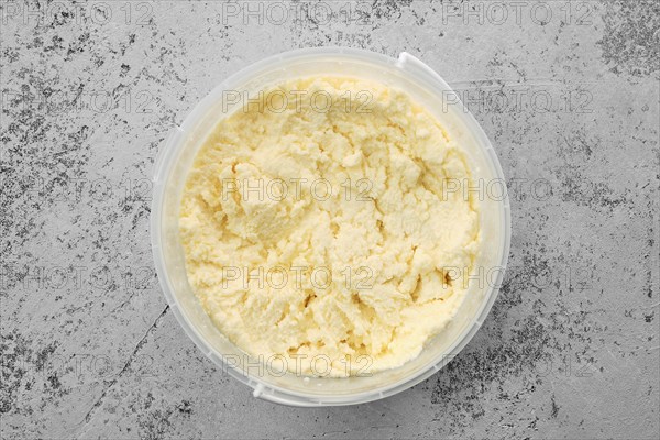 Top view of homemade processed cheese in plastic bowl