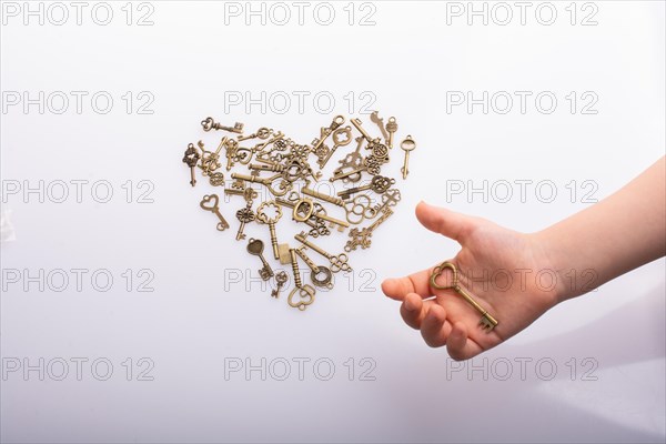 Retro metal keys form a heart shape on white
