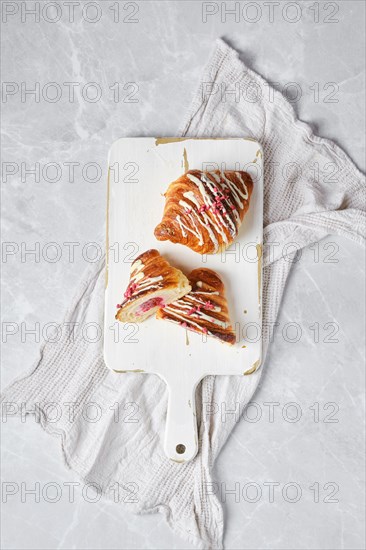 Top view of crispy croissant on wooden serving board