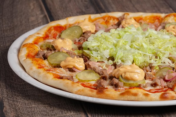 Part of pizza with meat and vegetables on wooden table