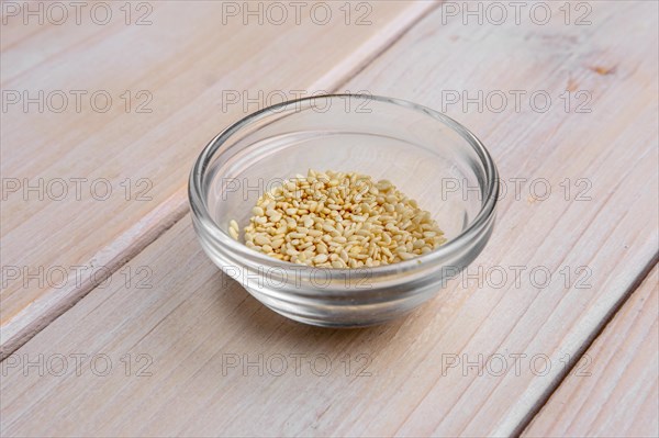 Sesame seeds in a little glass bowl on wooden table