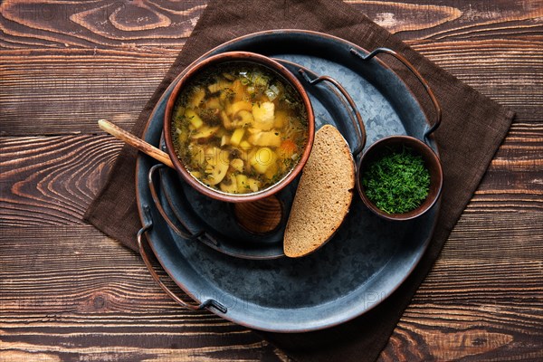 Overhead view of plate with champignon soup on wooden table