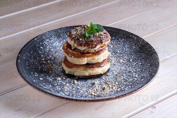 Fritters with peanut butter. Traditional Slavic pancakes with chocolate paste