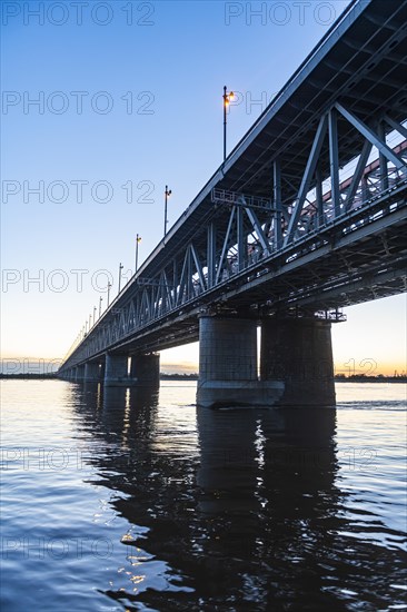 Giant bridge spanning over the Amur river at sunset