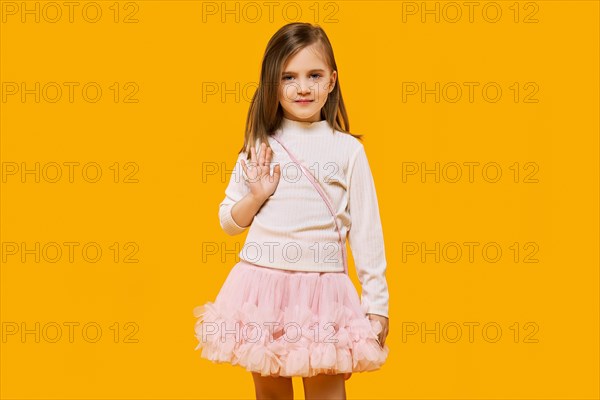 Cute little child posing on bright yellow background