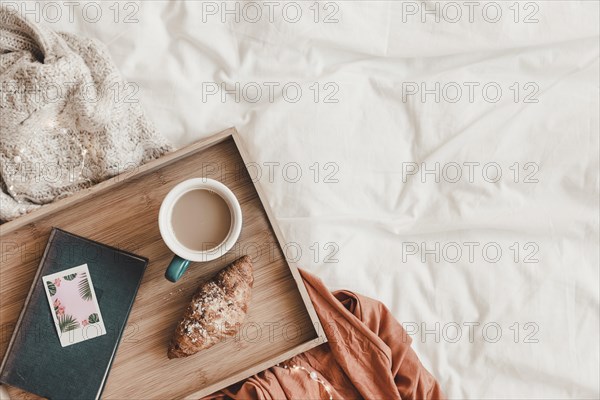 Croissant coffee near book bed