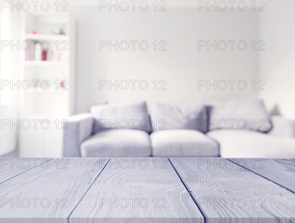 Gray wooden table front blur white sofa living room