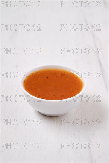 Small bowl with spicy orange sauce for poultry