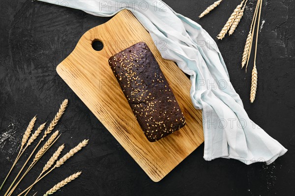 Top view of loaf of brown sourdough bread with sunflower seeds and sesame