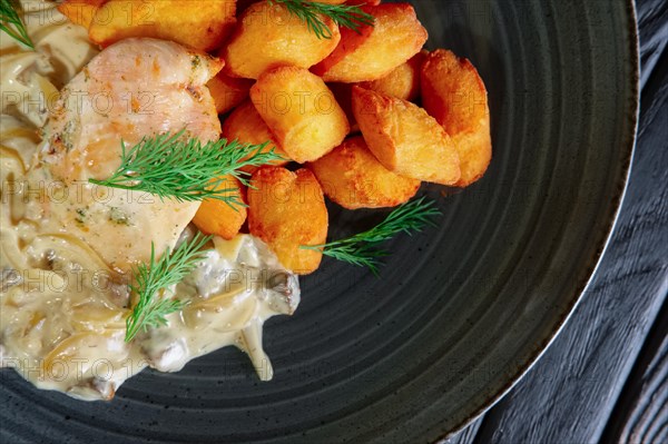 Closeup of potato balls with chicken fillet and mushroom and onion sauce