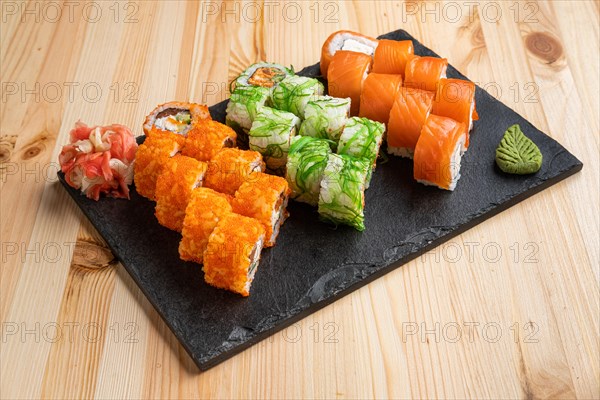 Set of rolls with wasabi and pickled ginger on stone serving board