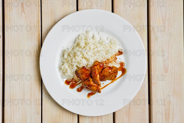 Top view of baked chicken fillet with rice and barbecue sauce