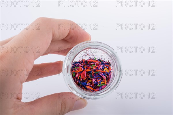 Little perfume glass bottle in hand on a white background