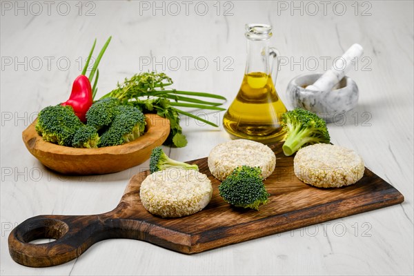 Semifinished homemade chicken cutlet with broccoli on a wooden serving board