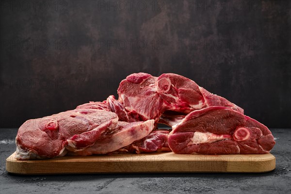 Assortment of raw fresh lamb meat on wooden tray