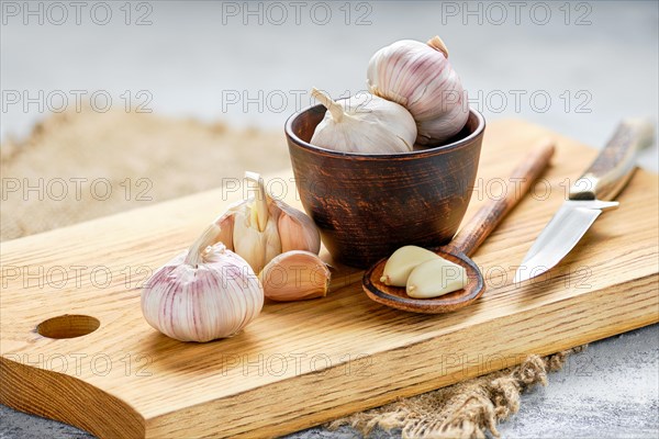 Garlic cloves and bulbs on wooden cutting board