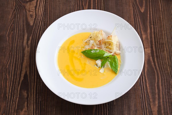 Top view of cheese soup with blue cheese and crouton on dark wooden background