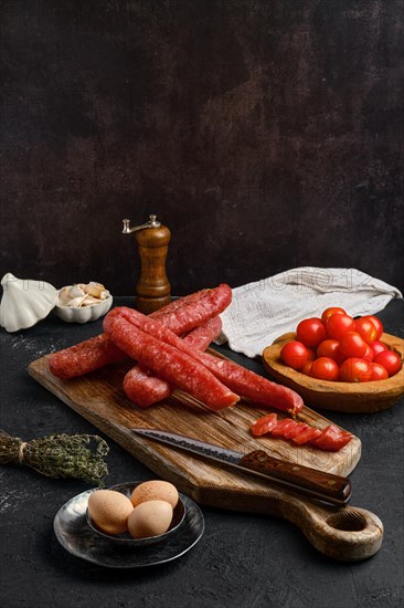 Air dried turkey sausage. Rustic lunch with eggs and tomato