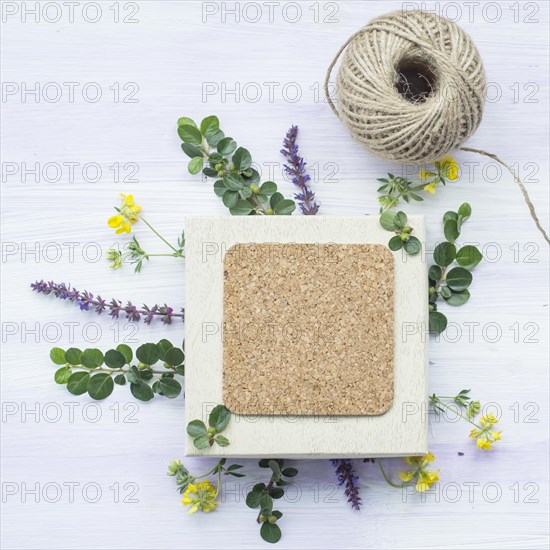 Cork frame with twig flowers string spool wooden textured backdrop
