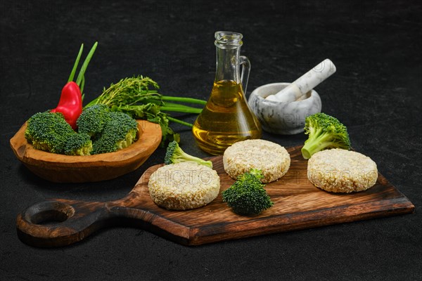 Semifinished homemade chicken cutlet with broccoli on a wooden serving board