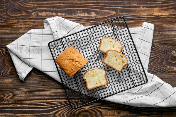 Overhead view of fresh biscuit cake with apple on wooden table