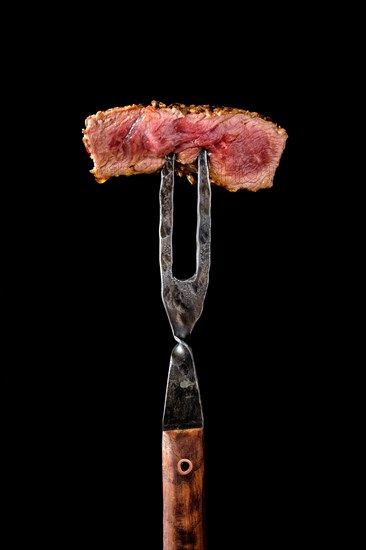 Piece of medium rare steak on the fork