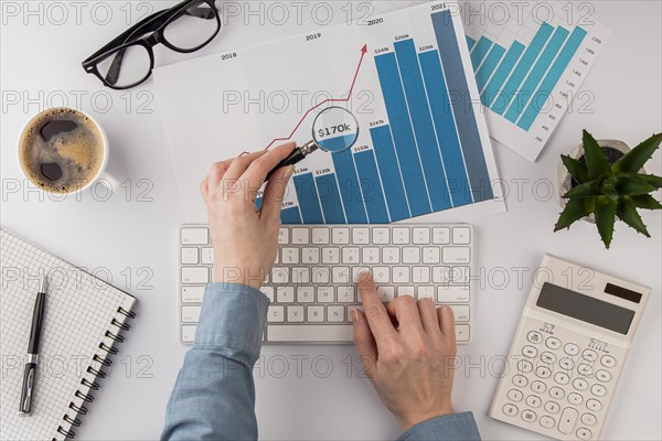 Top view office desk with growth chart analyzed with magnifying glass. Resolution and high quality beautiful photo