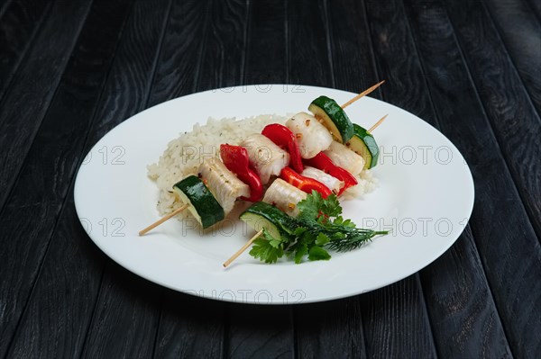 Grilled fish and vegetables on skewer with boiled rice